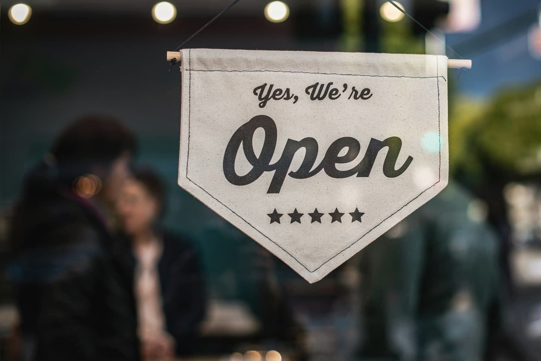 Enseigne « Yes, we're open » sur une vitrine de commerce